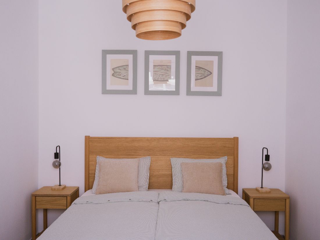 Double bedroom with oak headboard and framed surfboard prints