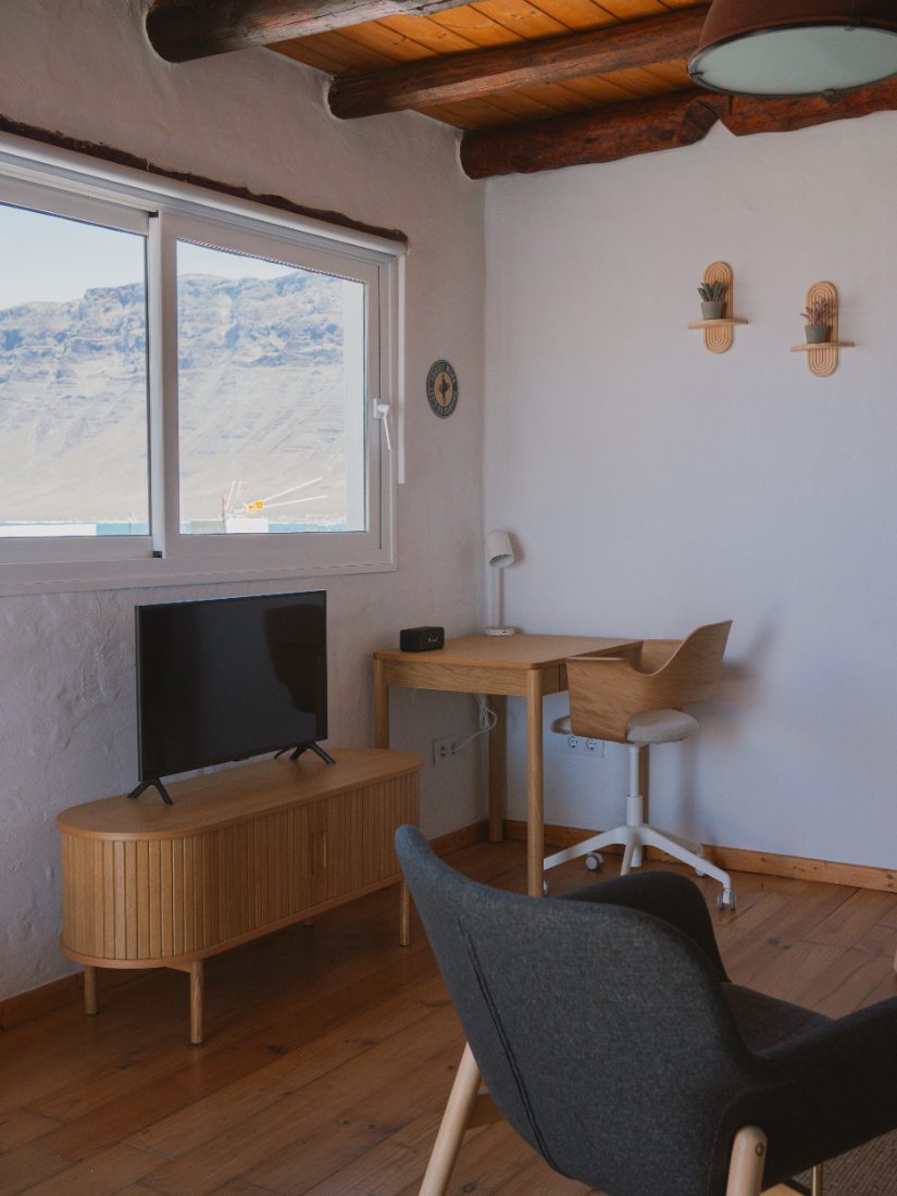 Desk and TV corner with a window view of the Risco de Famara