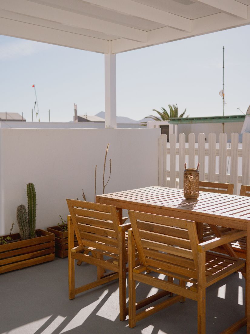 Roof terrace dining table and chairs under the white pergola