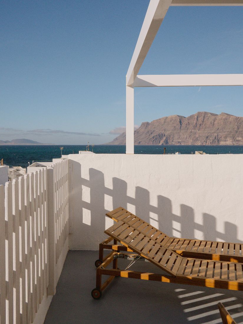 Wooden sun loungers on the roof terrace looking out to the sea and cliffs