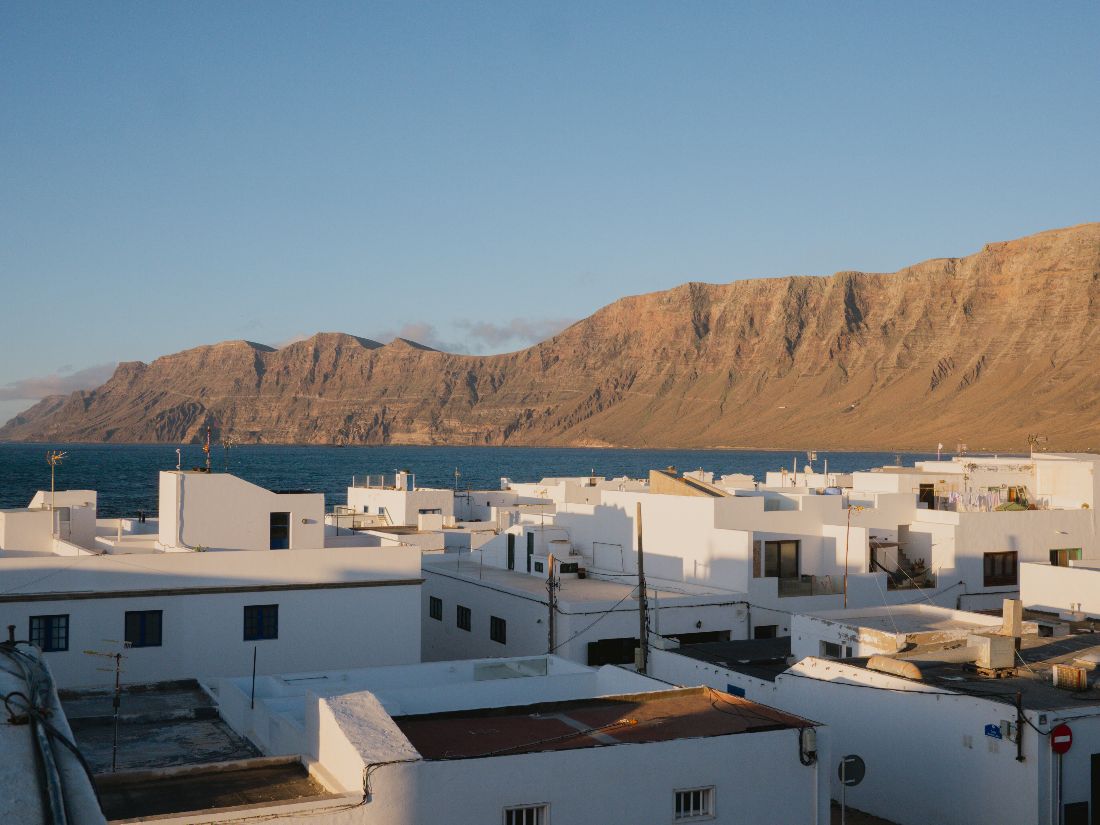 White rooftops of Caleta de Famara under the Risco de Famara