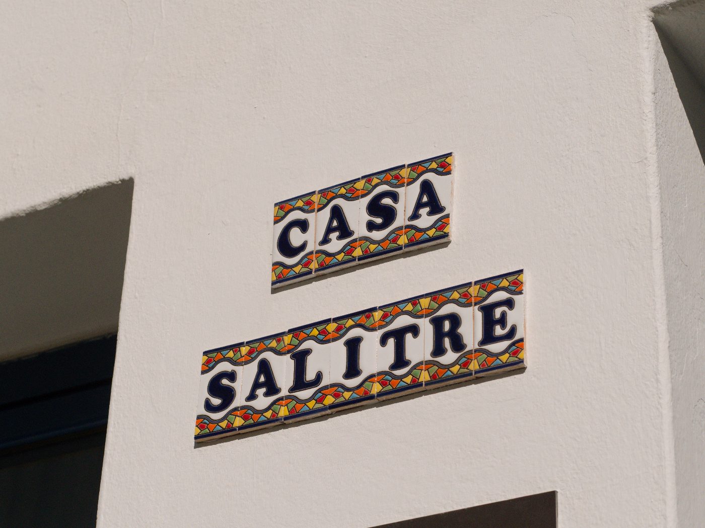 The hand-painted ceramic Casa Salitre tile sign on a whitewashed wall